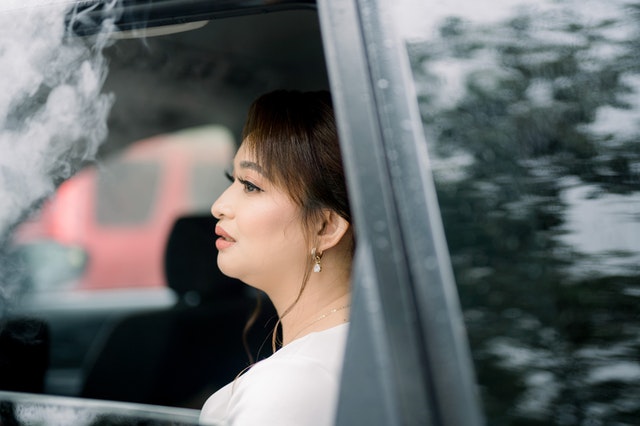 A woman vaping in the car